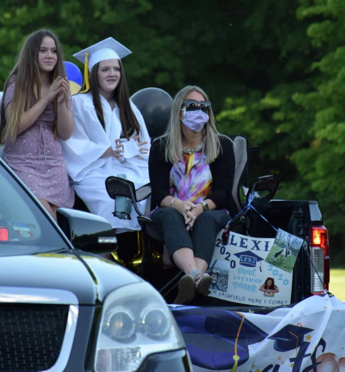 Graduate Lexi Murray and her family members watch the ceremony from the bed of their pickup truck.