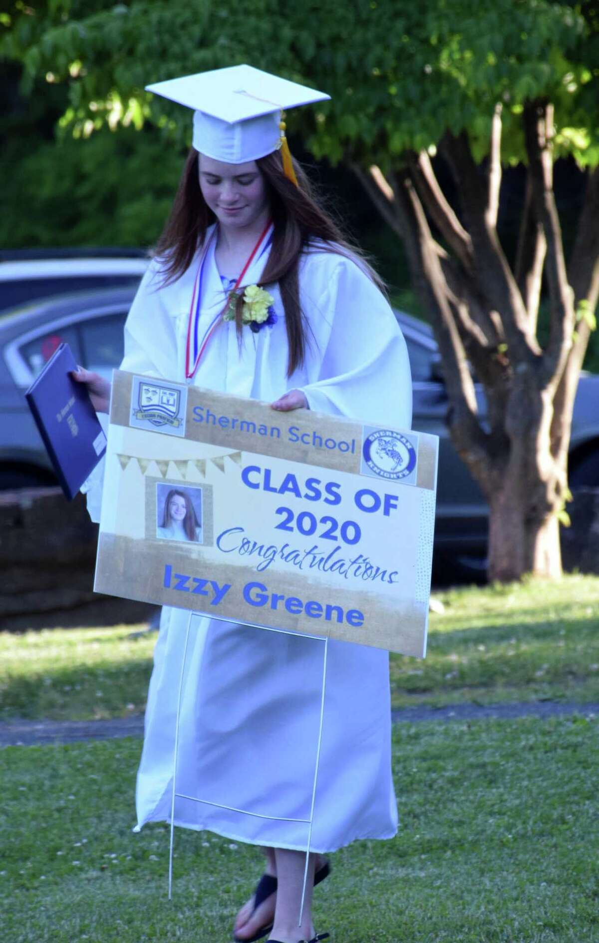 Spectrum/Sherman School held its eighth-grade graduation ceremony June 13, 2020 at Veterans Field. Students arrived in a vehicle, decorated for the occasion, filled with family and friends and parked at the field, where a ceremony was held adhering to social distancing guidelines. Above, Izzy Greene proudly walks back to her car after receiving her certificate.