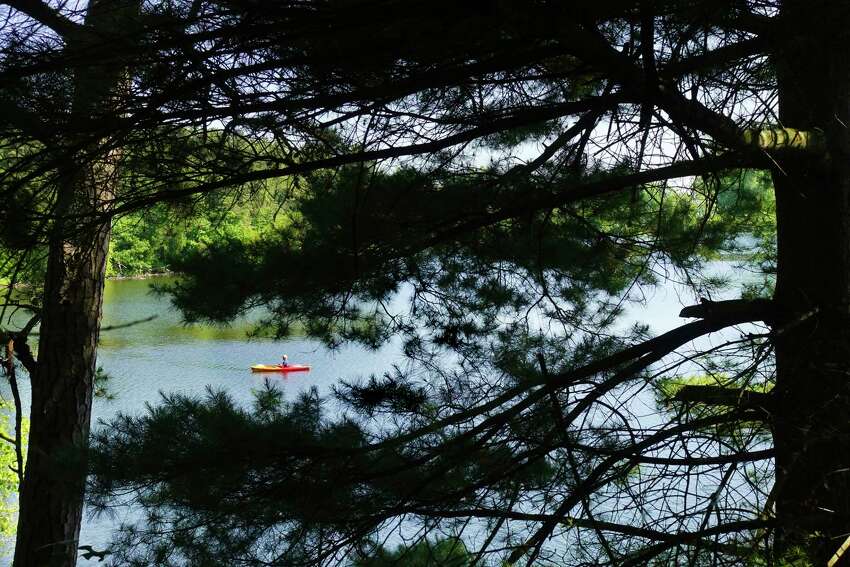 Seen through the trees, a man in a kayak fishes on Rensselaer Lake on Thursday, June 18, 20202, in Albany, N.Y. (Paul Buckowski/Times Union)