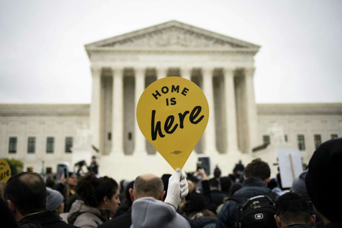 A demonstrator holds a "Home Is Here" sign during a rally supporting the Deferred Action for Childhood Arrivals program (DACA) outside of the Supreme Court in Washington, D.C., U.S., on Nov. 12, 2019.