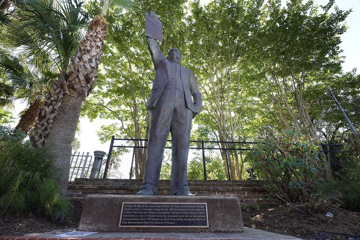 In this June 17, 2020, photo, a statue depicts a man holding the state law that made Juneteenth a state holiday in Galveston, Texas. The inscription on the statue reads "On June 19, 1865, at the close of the Civil War, U.S. Army General Gordon Granger issued an order in Galveston stating that the 1863 Emancipation Proclamation was in effect. That event, later known as "Juneteenth," marked the end of slavery in Texas. Celebrated as a day of freedom since then, Juneteenth grew into an international commemoration and in 1979 became an official Texas holiday through the efforts of State Representative Albert (AL) Edwards of Houston." (AP Photo/David J. Phillip)