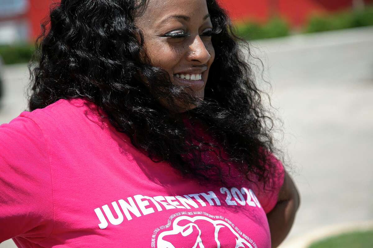 Kierra Alderman talks with a customer as she sells Juneteenth and Empowerment shirts and “movement mugs” with her husband, Reginald Alderman, in San Antonio on Tuesday, June 16, 2020.