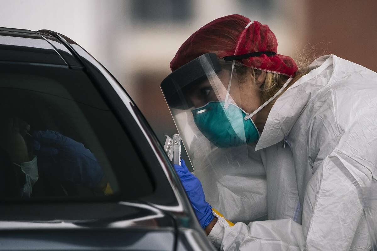 A medical worker collects a sample to test for COVID-19 novel coronavirus at CityTestSF Soma in San Francisco, Calif. on Friday, June 5, 2020.