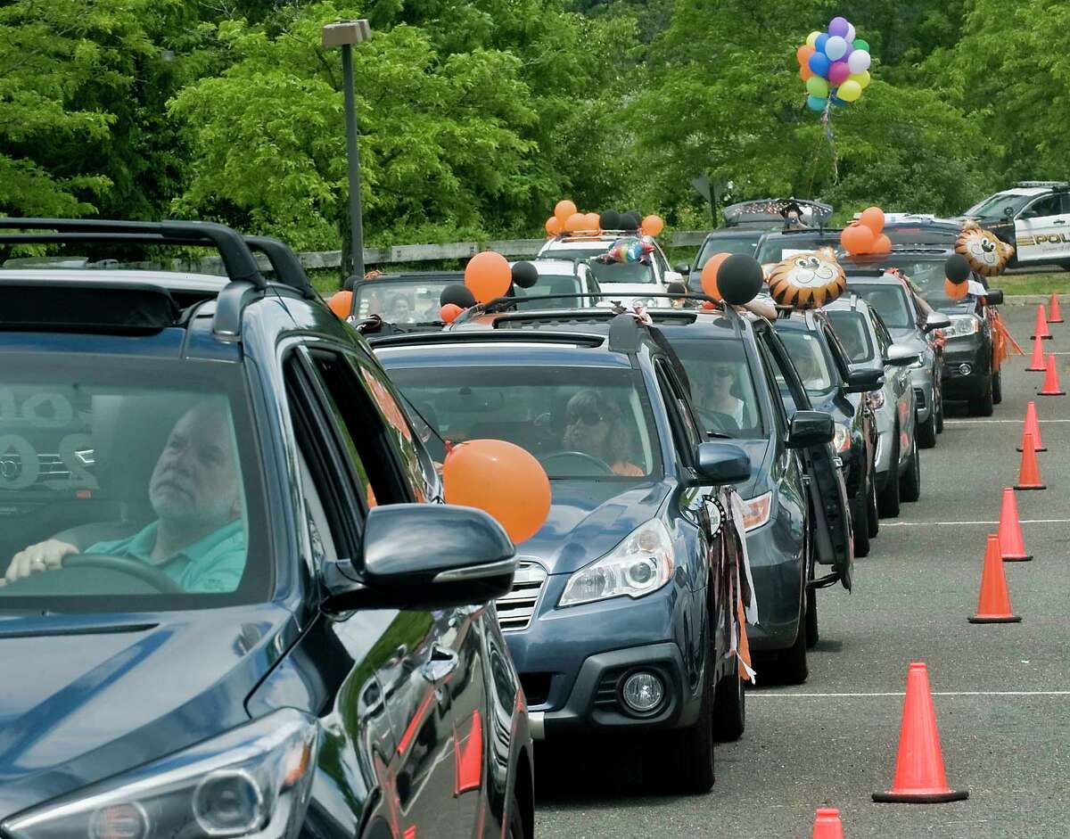 Cars lined up to watch the Ridgefield High School graduation ceremony on the big screen in the school parking lot. Thursday, June 18, 2020. Applause, cheers and the honking of horns followed speeches, and punctuated the reading of graduates' names.