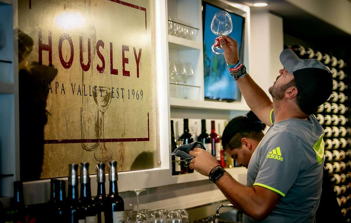 Adam Housley polishes a wine glass at the Housley winery tasting room in Napa, Calif. on October 12th, 2019.