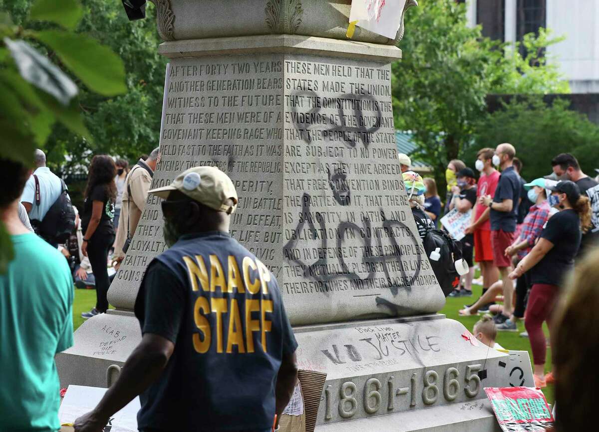 Local residents and protesters hold a rally calling on DeKalb County to follow a judge's order to "swiftly" remove the Confederate monument from Decatur Square, Wednesday, June 17, 2020, in Decatur, Ga. In an order issued Friday afternoon, DeKalb County Superior Court Judge Clarence Seeliger said the monument to the Confederacy in the square should be relocated by midnight on June 26. The city argued that the 30-foot obelisk had become a threat to public safety during recent protests about racism and police violence toward black people. Seeliger's order says the monument should be placed into storage until further notice. (Curtis Compton/Atlanta Journal-Constitution via AP)
