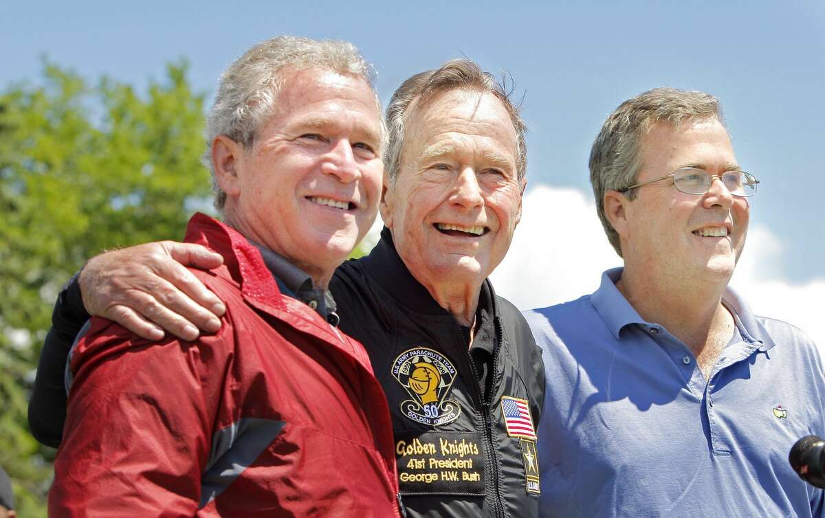 Former President George H. W. Bush poses with his sons former President George W. Bush and Jeb Bush.