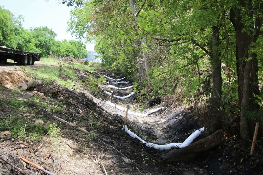 One ditch has boons lined for almost a quarter-of-a-mile where the oily substance has been found. The ditch runs adjacent to a water canal that carries water to several petrochemical facilities, MUD districts, and irrigation customers. Photo: David Taylor / Staff Photo