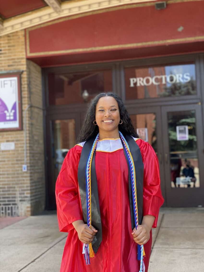 Schenectady High School senior Maram Ahmed, 18, poses in graduation attire in front of Proctor's Theatre.
