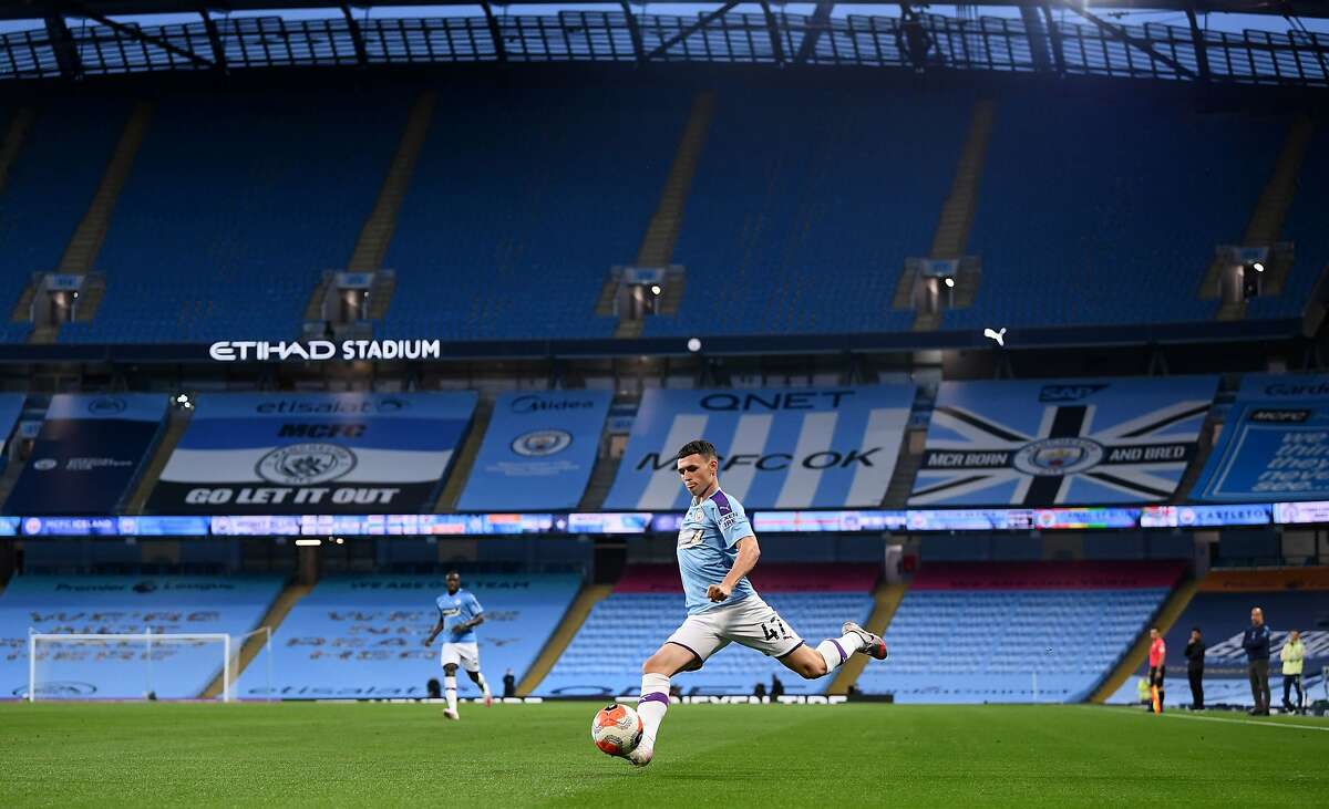Manchester City's English midfielder Phil Foden crosses the ball in an empty stadium during the English Premier League football match between Manchester City and Arsenal at the Etihad Stadium in Manchester, north west England, on June 17, 2020. - The Premier League makes its eagerly anticipated return today after 100 days in lockdown but behind closed doors due to coronavirus restrictions. (Photo by LAURENCE GRIFFITHS / POOL / AFP) / RESTRICTED TO EDITORIAL USE. No use with unauthorized audio, video, data, fixture lists, club/league logos or 'live' services. Online in-match use limited to 120 images. An additional 40 images may be used in extra time. No video emulation. Social media in-match use limited to 120 images. An additional 40 images may be used in extra time. No use in betting publications, games or single club/league/player publications. / (Photo by LAURENCE GRIFFITHS/POOL/AFP via Getty Images)