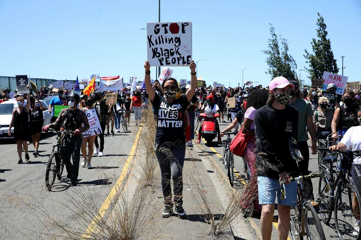 People march along Adeline St. during a Juneteenth protest against police brutality, as longshoremen shut down the Port of Oakland and 28 other ports along the west coast on Friday, June 19, 2020, in Oakland, Calif.
