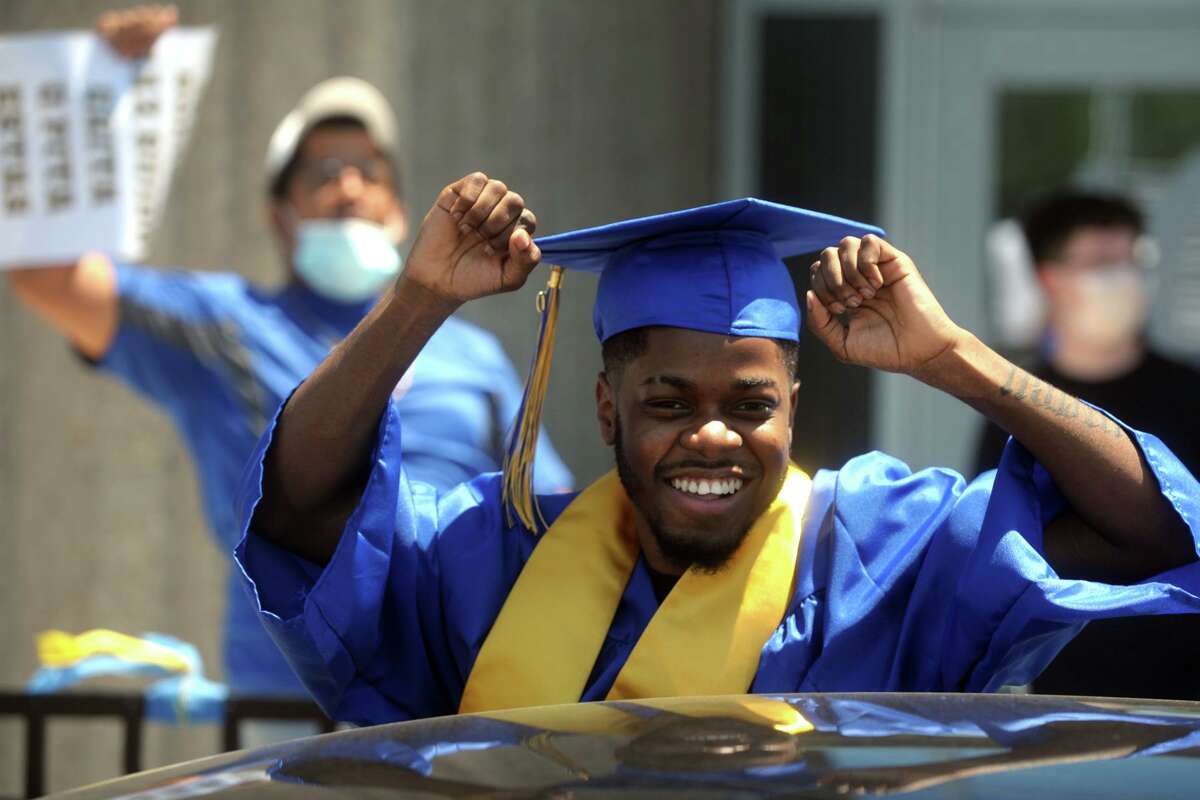 Kojo Maxwell celebrates from the sunroof of his car during graduation for the Harding High School Class of 2020, in Bridgeport, Conn. June 19, 2020.