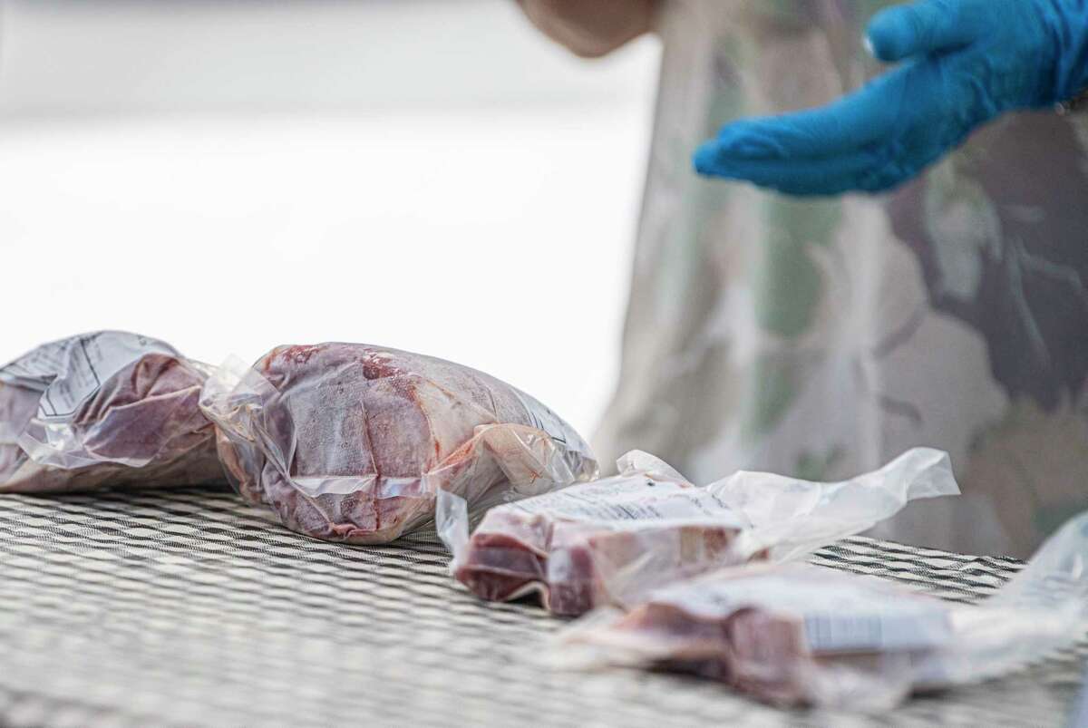 Terrapin Farms owner, Chris Summers, shows costumers different cuts of Texas Droper Lamb during the Pearl Farmers Market.