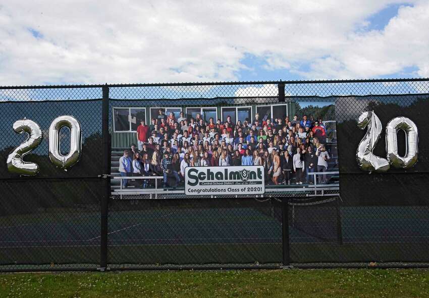 A poster of the class of 2020 photo is hung on the fence of the tennis courts as graduates pick up their diplomas during a drive through graduation at Schalmont High School on Friday, June 19, 2020 in Rotterdam, N.Y. (Lori Van Buren/Times Union)