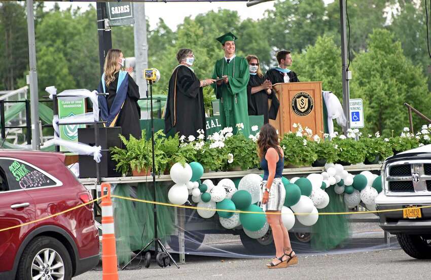 Graduate Giovanni DellaPorta poses for a photo with school superintendent Dr. Carol Pallas as graduates pick up their diplomas during a drive through graduation at Schalmont High School on Friday, June 19, 2020 in Rotterdam, N.Y. (Lori Van Buren/Times Union)