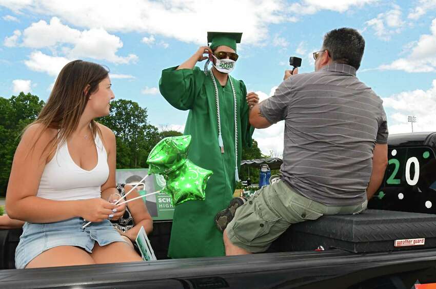 Graduate Dillon DiGirolamo puts on his face mask in the back of his family's pickup truck as graduates pick up their diplomas during a drive through graduation at Schalmont High School on Friday, June 19, 2020 in Rotterdam, N.Y. (Lori Van Buren/Times Union)