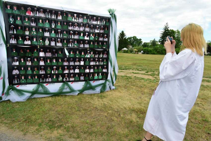 Graduate Kayleigh Finch takes a photo of her classmates of 2020 as graduates pick up their diplomas during a drive through graduation at Schalmont High School on Friday, June 19, 2020 in Rotterdam, N.Y. (Lori Van Buren/Times Union)