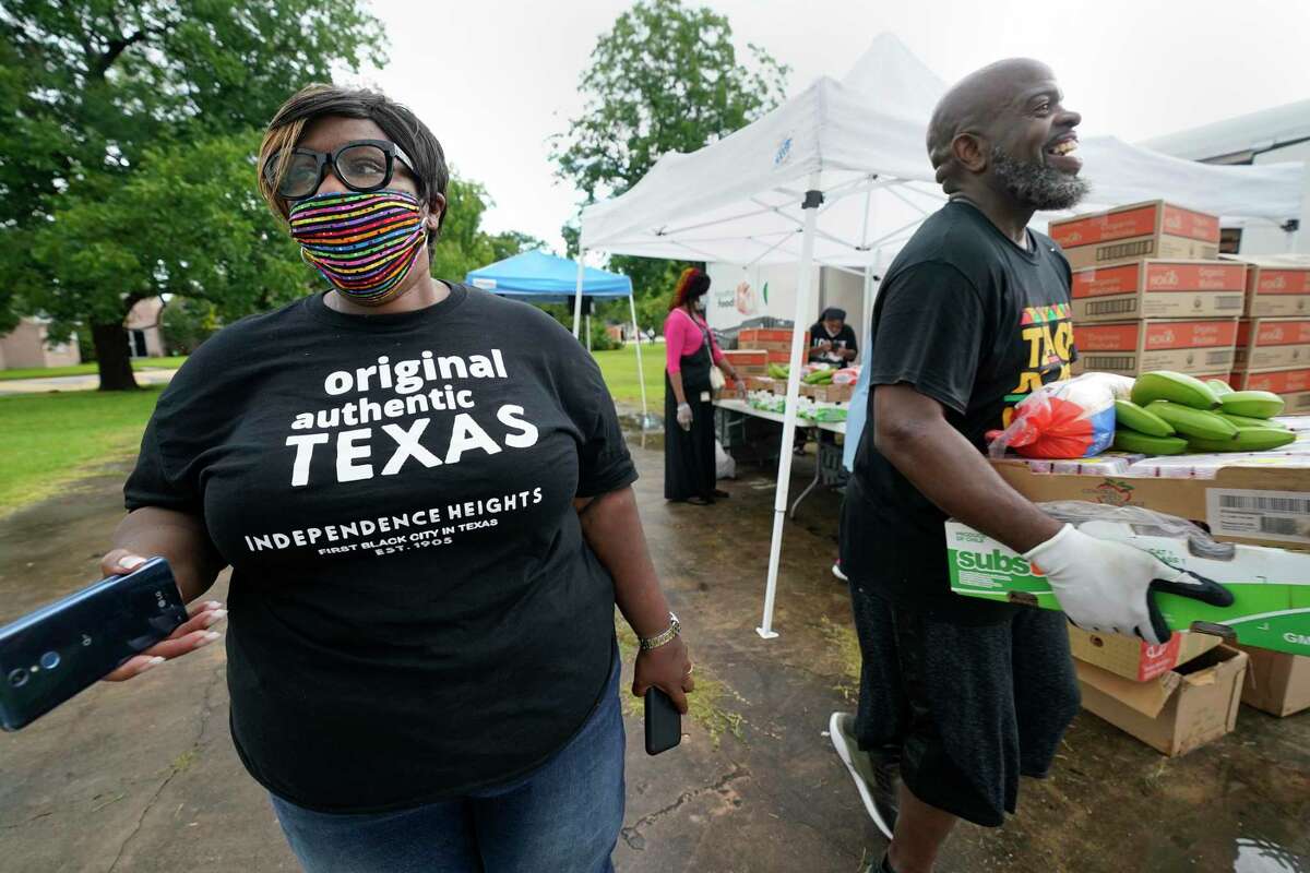 Tanya Debose, Independent Heights civic leader, left, Marques Francis, right, and other volunteers work in the rain at a free food distribution during the "Black Towns Matter" event in celebration of Juneteenth held outside of Ebenezer United Methodist Church in Independent Heights Friday, June 19, 2020, in Houston.