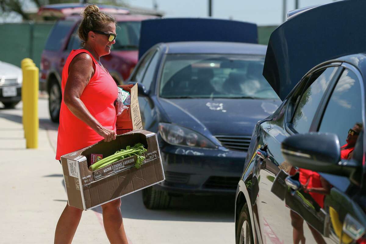 Kitty Hawk Middle School teacher Cindy Hubbard helps distribute boxes of food to district residents in the Judson ISD “Kick Off to Summer Food Drive” at the school on June 8.