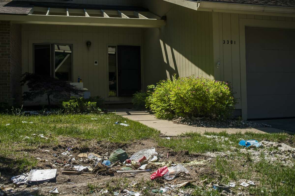 Debris lies in the front lawn of a home at Village West Condominiums Wednesday, June 17, 2020. (Katy Kildee/kkildee@mdn.net)
