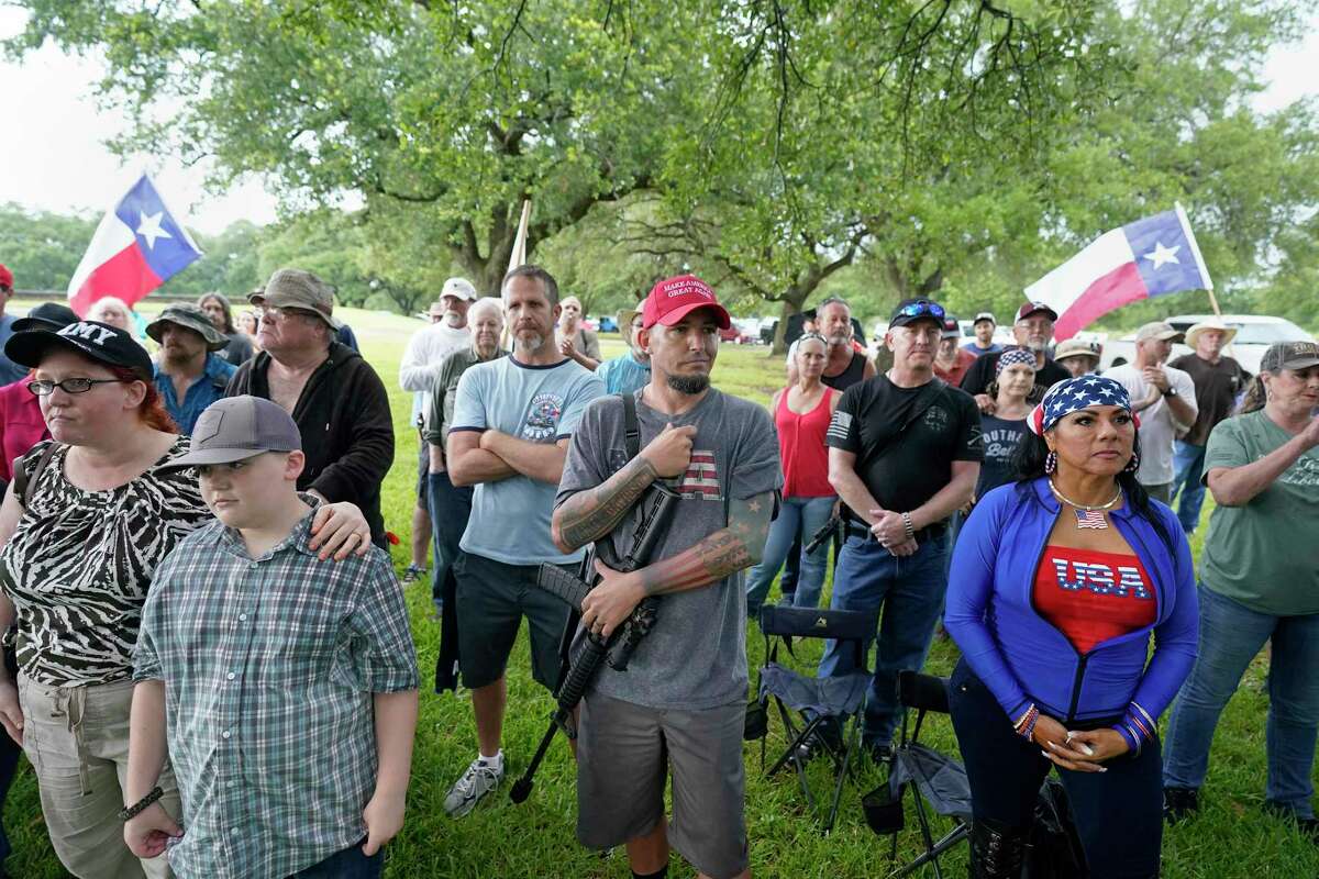 Clint Buss of Baytown, center, holds an AR-15 rifle during the This Is Texas Freedom Force rally at the San Jacinto Monument on Saturday. The group gathered to guard the monument.