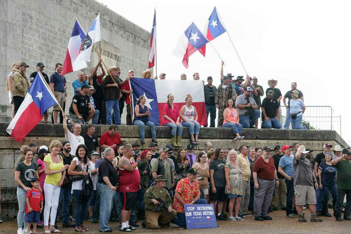 People gather for group photos and a video during the This Is Texas Freedom Force rally at the San Jacinto Monument on Saturday.