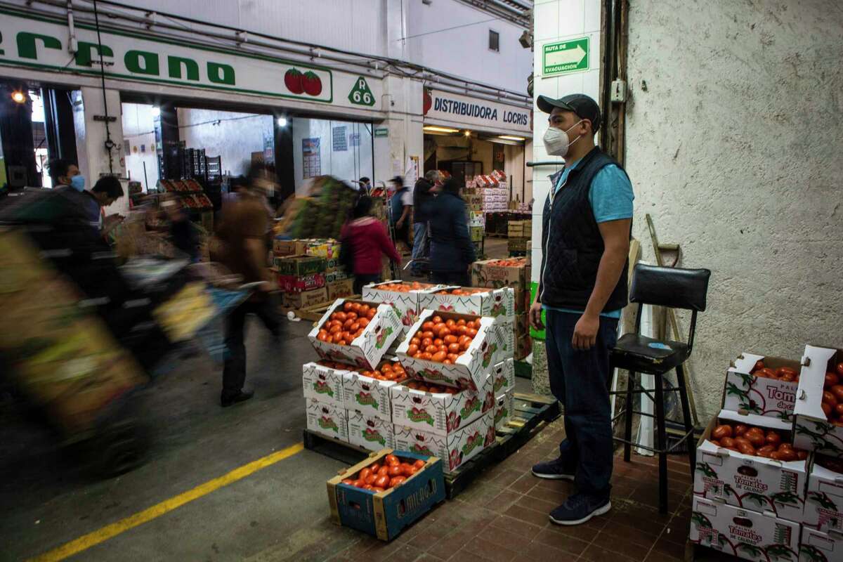 Carlos Molina, 31, whose father, Martin Mateo, 50, died of covid-19,, stands at the entrance of his family's tomato stall at the Central de Abastos in Mexico City on June 12, 2020.