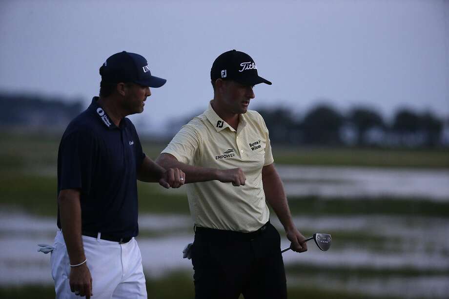 Webb Simpson (right) is congratulated by Ryan Palmer after finishing his round of 7-under-par 64 at Harbour Town. Photo: Gerry Broome / Associated Press