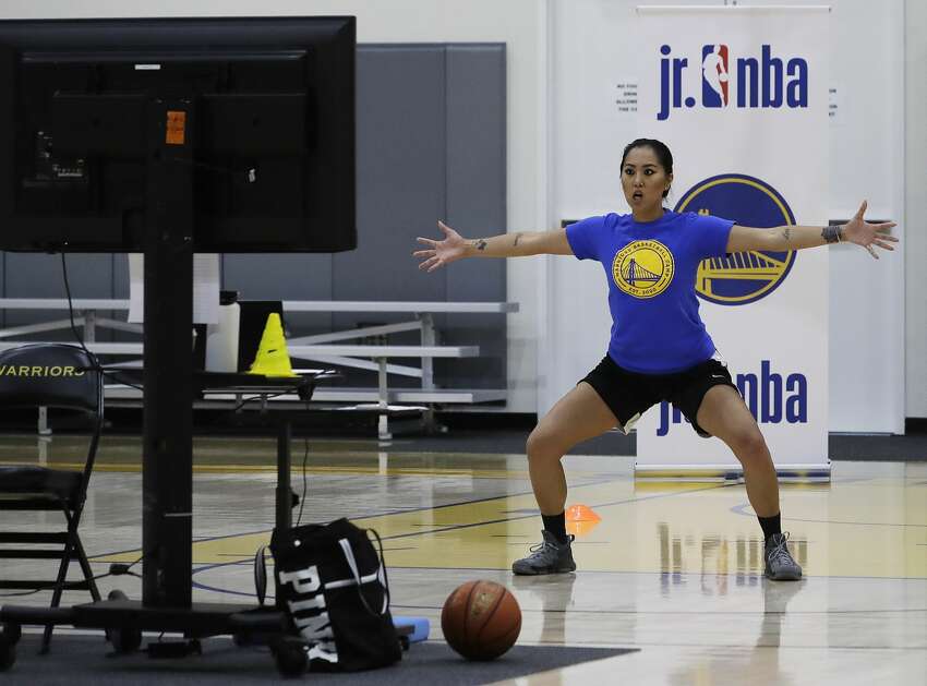 In this photo taken on Tuesday, June 9, 2020, coach Chanel Antonio leads a drill with her virtual students at Golden State Warriors basketball camp in Oakland, Calif. The Warriors had to adapt their popular youth basketball camps and make them virtual given the COVID-19 pandemic.