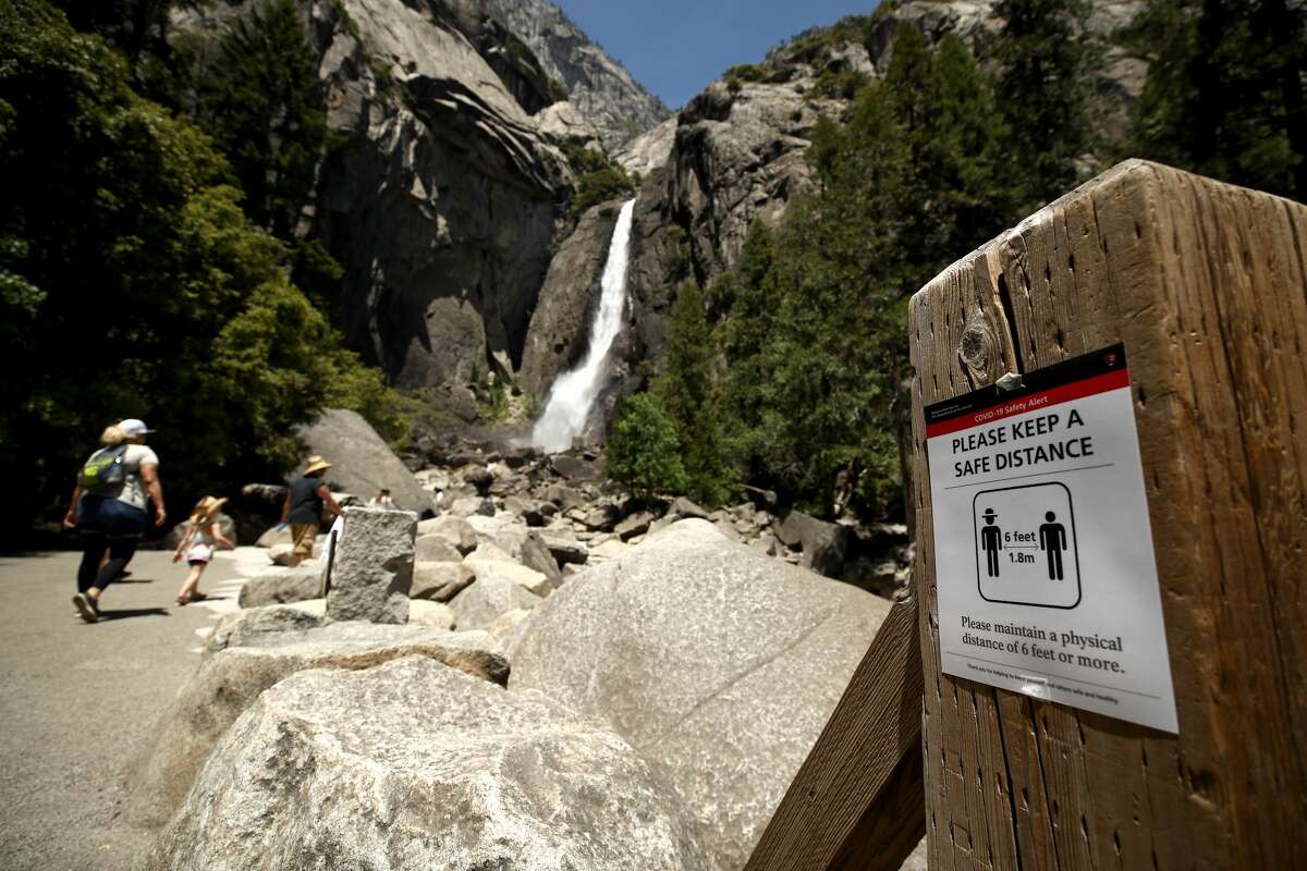 A sign explaining social distancing at Yosemite Falls on June 11, 2020 in Yosemite National Park, California.