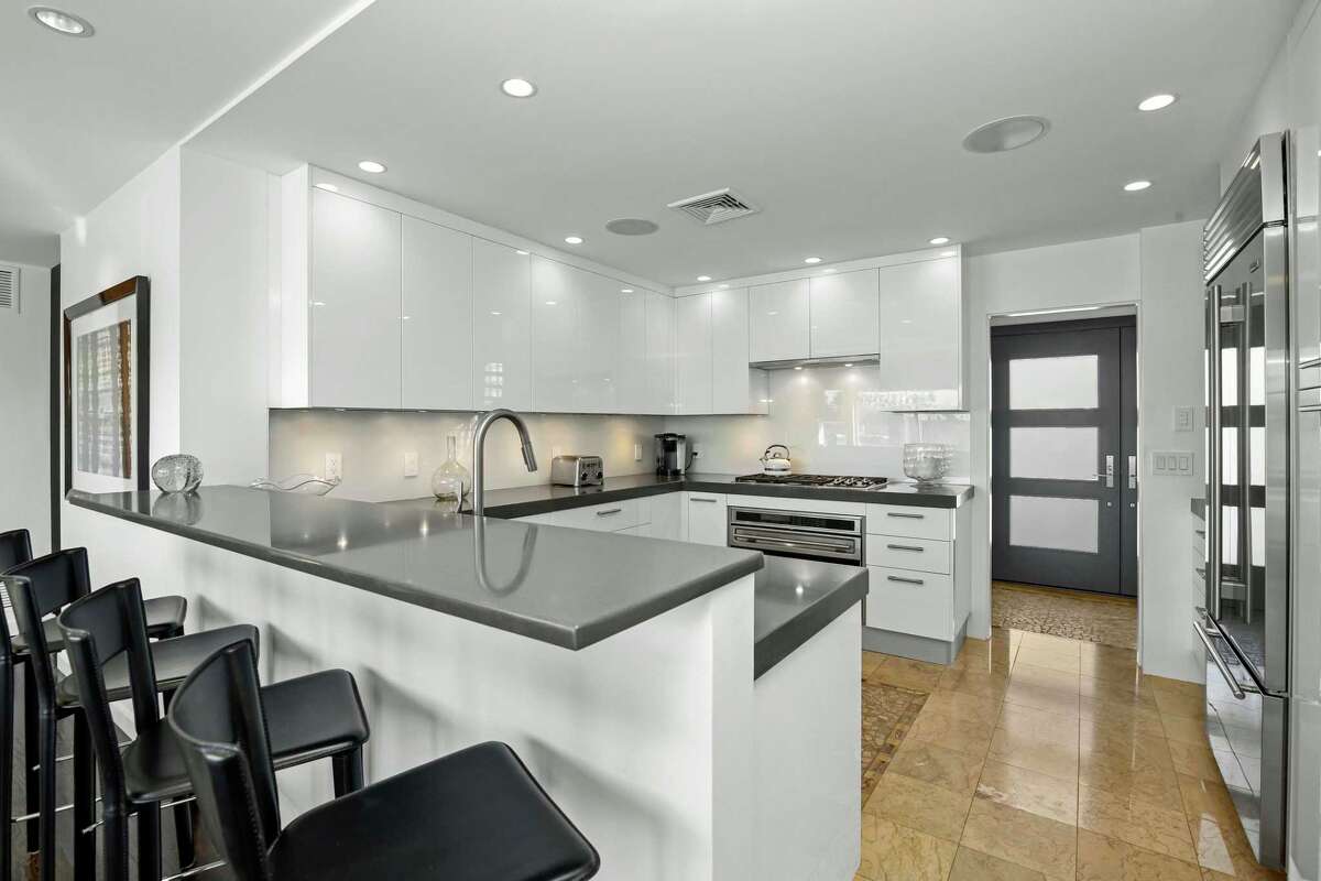 In the chef’s kitchen there is a two-tiered counter with a breakfast bar for four stools. FEATURES: waterfront community, direct waterfront property, dock or mooring, walk to private community beach and boat launch, water views of Long Island Sound, 0.26 of an acre level property, flagstone patio, wrap-around deck, multiple balcony/deck spaces, roof deck, awnings, exterior lighting, underground sprinkler, professional landscaping including specimen plantings, sauna, gym; only minutes to Saugatuck section with Metro North train station, restaurants and shops; walking distance to Cedar Point Yacht Club, just one hour from NYC, generator, programmable thermostat, homeowners association, audio system, pre-wired for cable, central vacuum, two fireplaces, zoned central air conditioning and oil heat, attached one-car garage, public water and sewer connections, flat roof, crawl space, located in a flood zone, three bedrooms, three full and one half baths