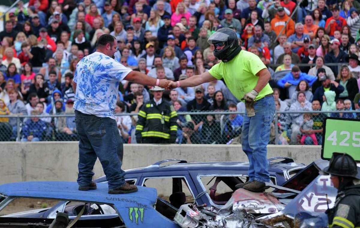 Drivers congratulate each other Monday night after the first heat of the Demolition Derby at the Washington County Fair in Greenwich. ( Philip Kamrass / Times Union )