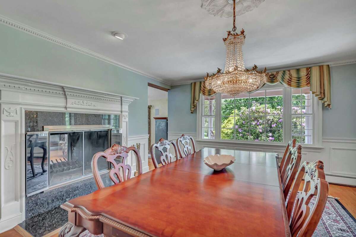 In the formal dining room there is a marble fireplace with a decorative mantel, and dentil crown molding. In the formal dining room there is a tall marble fireplace flanked by entrances into the vaulted great room, where there is a floor-to-ceiling stacked stone fireplace with a raised hearth and firewood storage, and a wall of sliding glass doors to the yard. Also on the first floor is the formal living room and study or office.