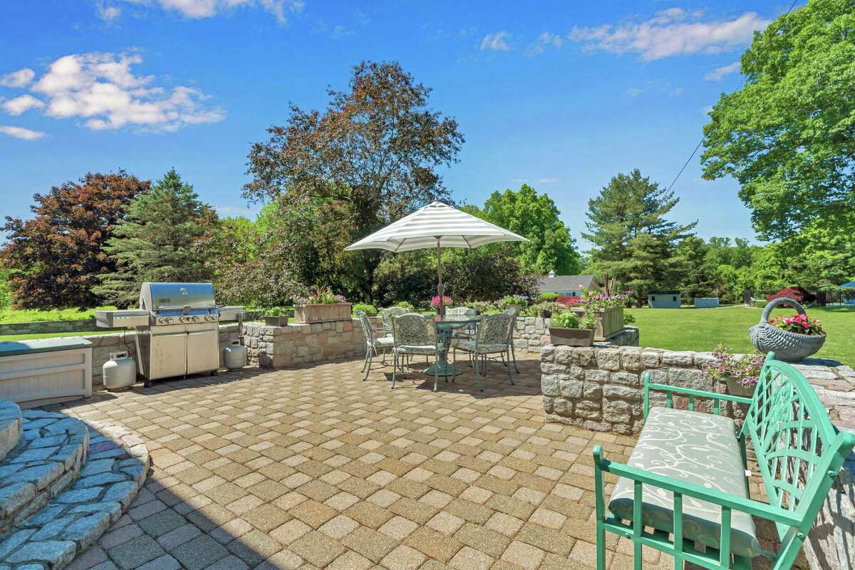 The paving stone patio features a grilling area and sitting wall. This property not only serves as its own country club, but it is not far from an actual country club should the next owner want to venture from their own boundaries. In the backyard there is a renovated in-ground salt water swimming pool and a well-equipped guest/pool house. It features a long, impressive service bar that can accommodate six stools, and a full bath, making it ideal for entertaining. It could also serve as an in-law or au pair suite. Also found on this professionally landscaped lot is a paving stone patio with stone sitting walls. The landscaping includes mature trees, specimen plantings, and a garden area.