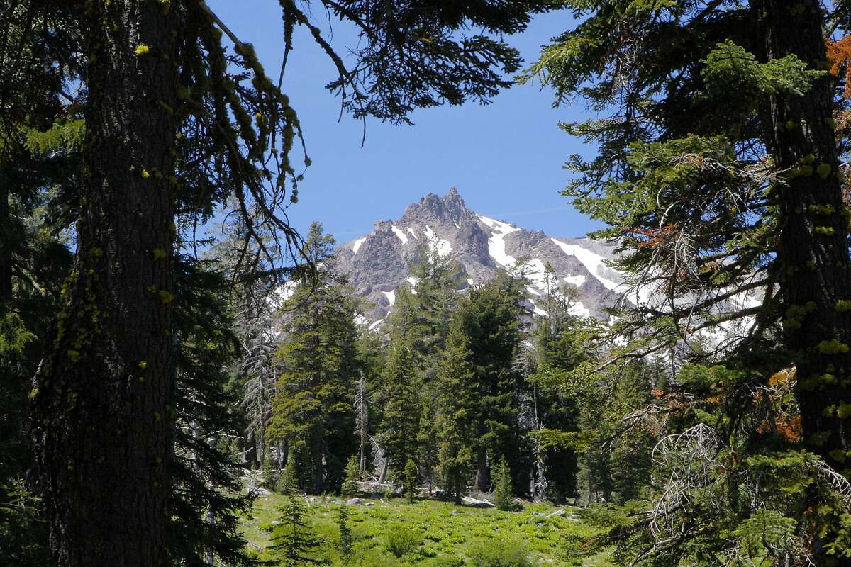 A break in the forest on the trail to Paradise Meadow reveals a framed view of Lassen Peak at Lassen Volcanic National Park