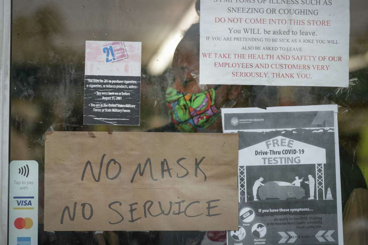 A sign on Ralston Discount Liquor door had signs informing patrons that Harris County Judge Lina Hidalgo has issued an order mandating that businesses in the county must require customers wear masks to slow the spread of the novel coronavirus Monday, June 22, 2020, in Houston. Employees and customers over the age of 10 must wear a mask or face covering, stay 6 feet apart from other customers and staff, and cannot enter a business if they are feeling ill.
