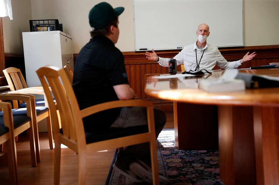 HealthRight 360 therapist Charles Newcomb (right) leads a stress management workshop as client Brian Parner listens. Treatment before the pandemic was challenging, and COVID-19 has made it more difficult. Photo: Scott Strazzante / The Chronicle