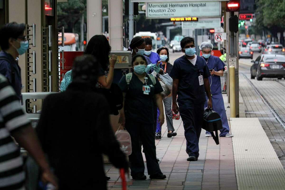 Medical workers wait to ride the light rail Monday, June 22, 2020, at the Texas Medical Center in Houston.