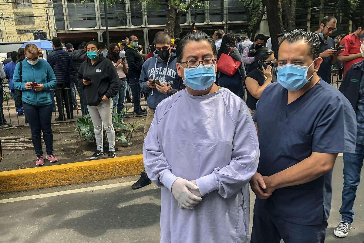 Health workers and other people remain outside the Durango clinic in Mexico City during a quake on June 23, 2020 amid the COVID-19 novel coronavirus pandemic. - A 7.1 magnitude quake was registered Tuesday in the south of Mexico, according to the Mexican National Seismological Service. (Photo by Pedro PARDO / AFP) (Photo by PEDRO PARDO/AFP via Getty Images)