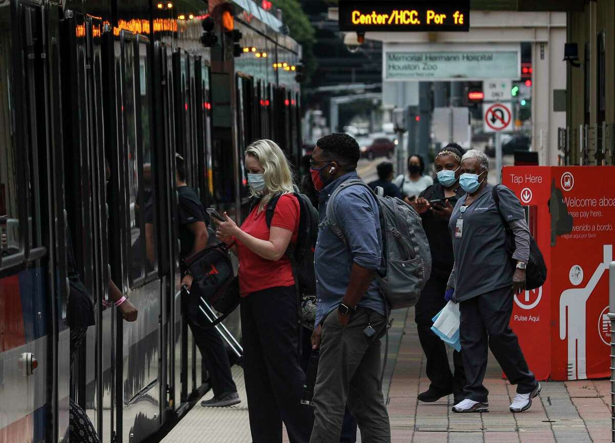 Medical workers wait to ride the light rail Monday, June 22, 2020, at the Texas Medical Center in Houston.