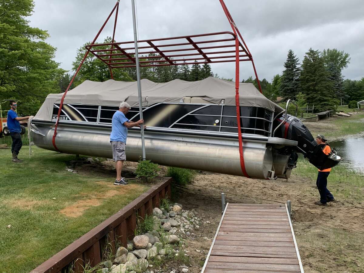 Justin Hartmann's crane begins to lift a pontoon out of a dry river bed at a Maple Lane residence in Beaverton on Tuesday.