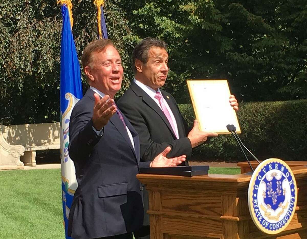 Connecticut Gov. Ned Lamont, left, and New York Gov. Andrew Cuomo share a laugh after Lamont gave Cuomo a mounted Connecticut fishing license at the governor's mansion in Hartford, Sept. 25, 2019.