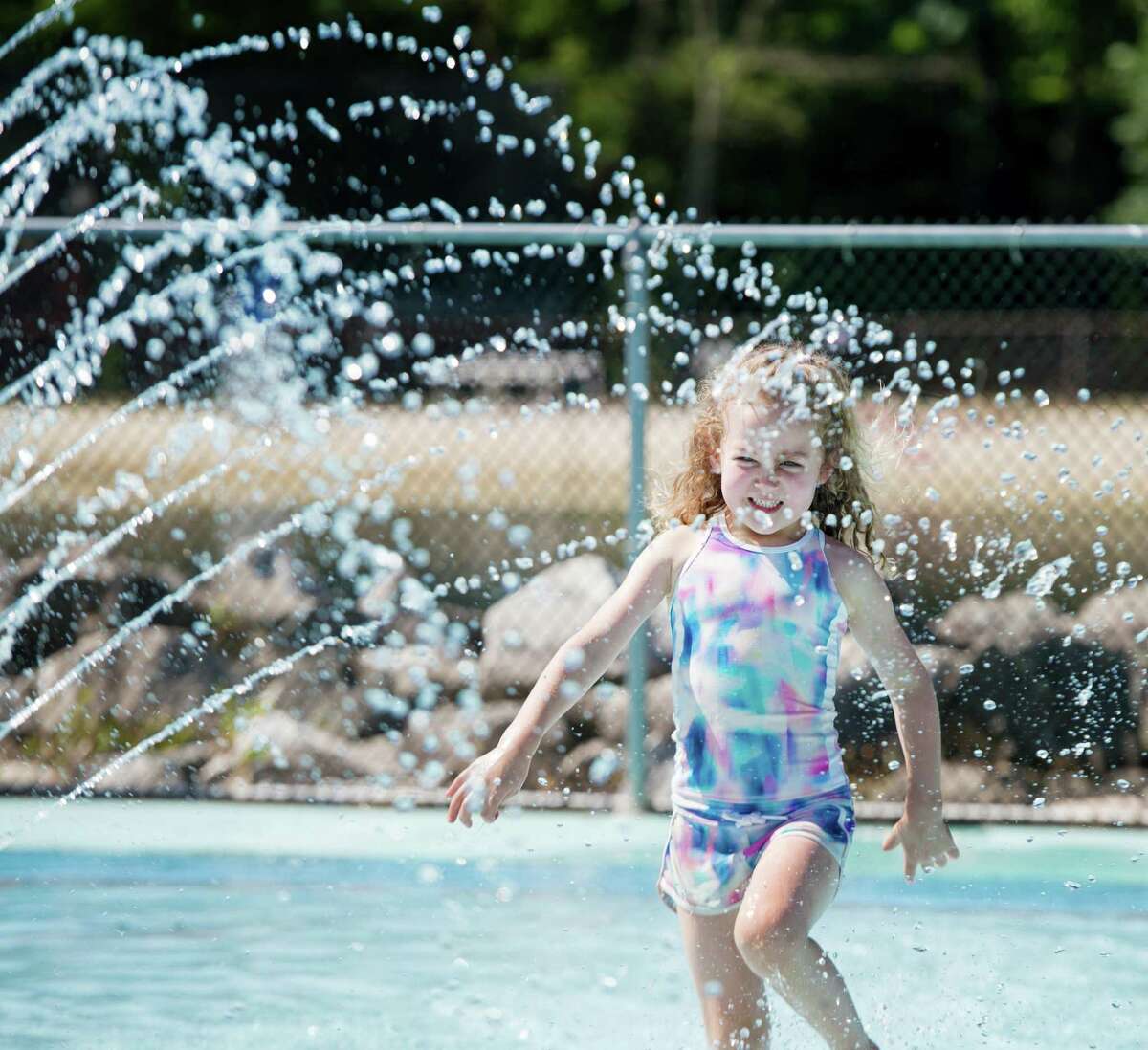 Cecilia McNeil cools off in the splash pad at the Wilton Y’s Camp Gordyland on Monday, June 22.