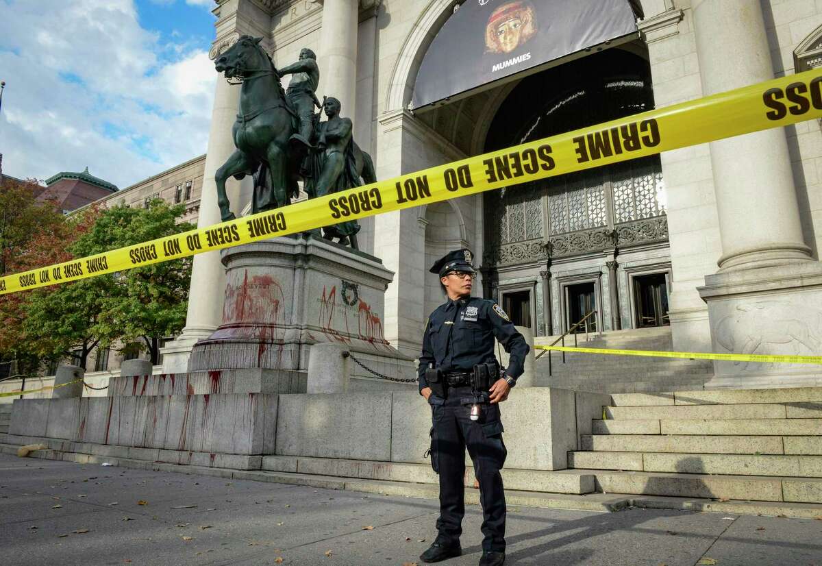 An NYPD police officer watches over the area after vandals splash red paint on the Theodore Roosevelt statue atthe American Museum of Natural History. A reader worries about the reminders of Roosevelt in San Antonio.