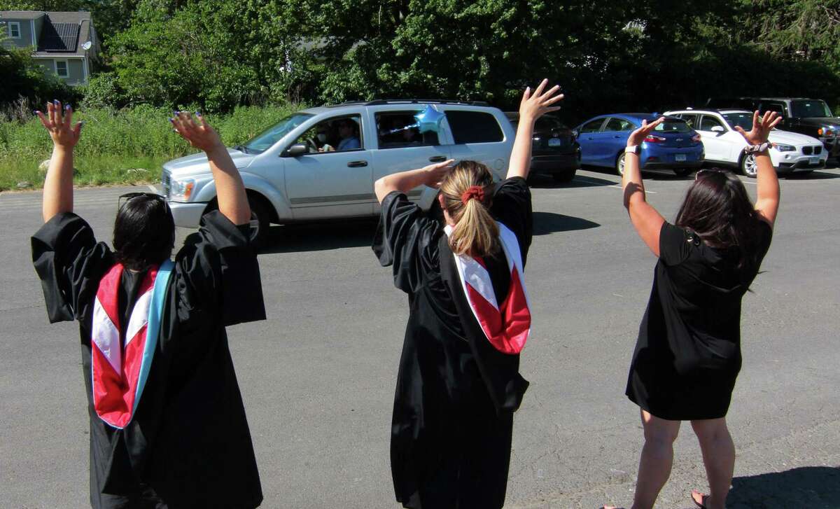 Teachers cheer as each graduate arrives during Bunnell High School’s 60th commencement in Stratford on Wednesday. To observe social distancing, graduates were brought in in groups of 15 and walked onto the football field with their families.