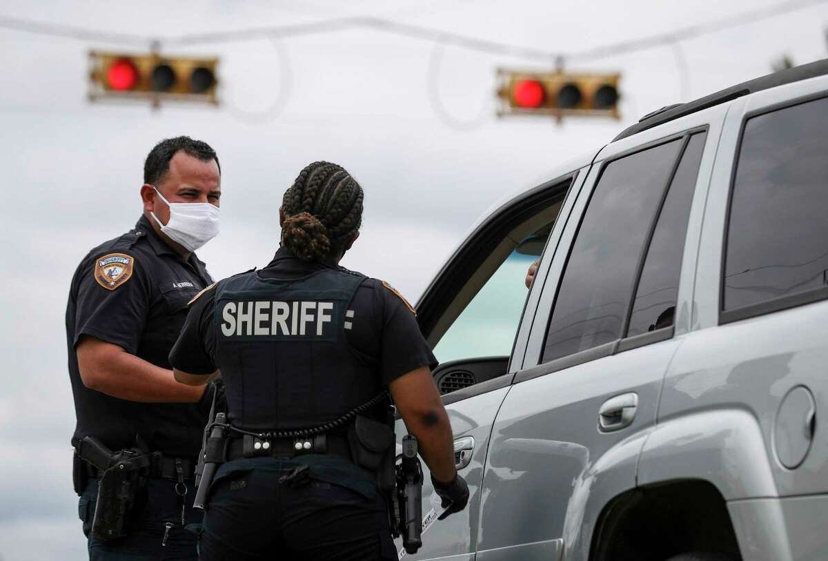 Harris County Sheriff's deputies Aaron Herrera, left, Nakeitha Dussette speak to a woman after Dussette made a traffic stop Wednesday, June 24, 2020, at the intersection of Bellaire Boulevard and Metro Boulevard in Houston.