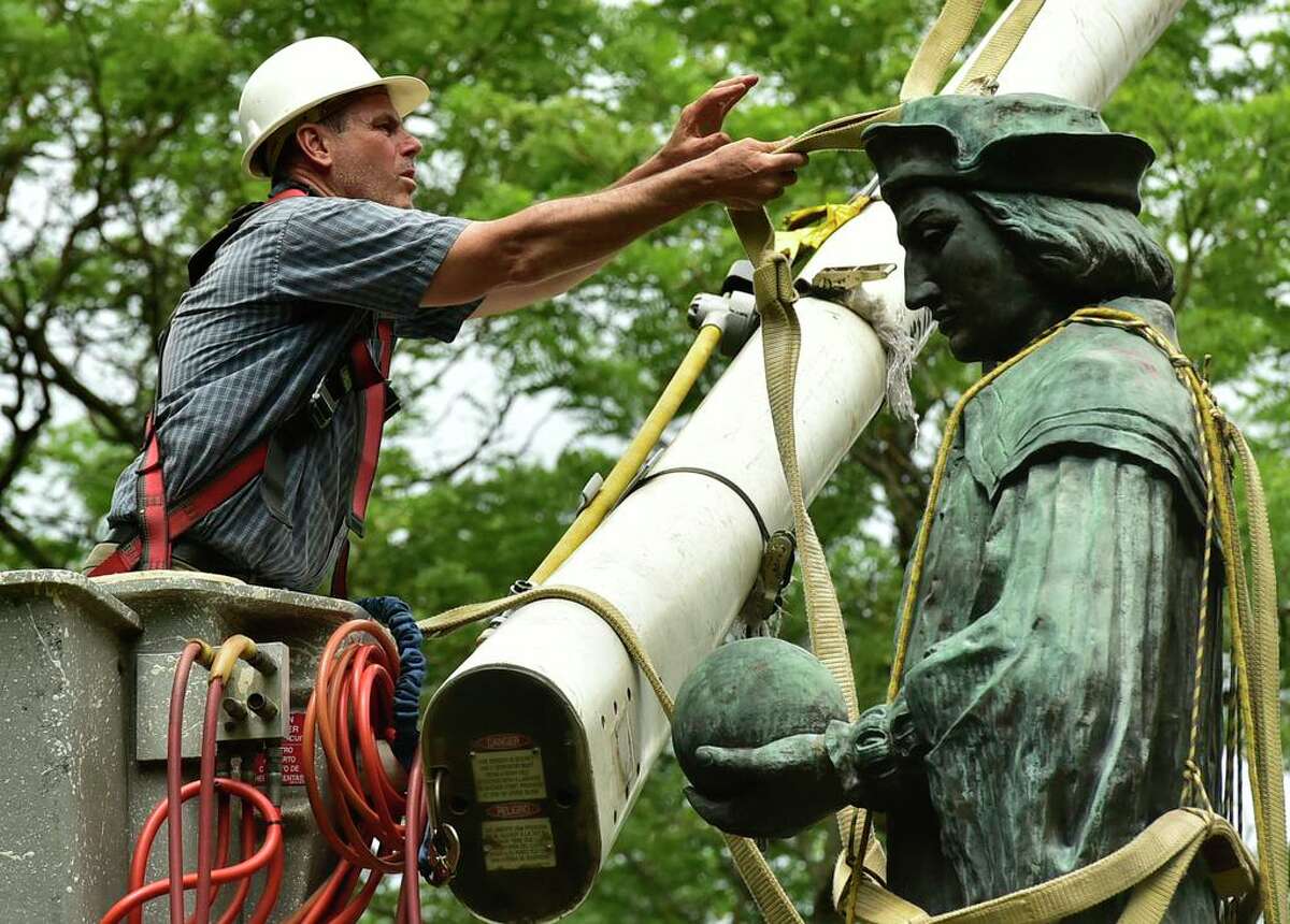 The statue of Christopher Columbus is removed from Wooster Square Park, in New Haven, Conn. Wednesday, June 24, 2020.