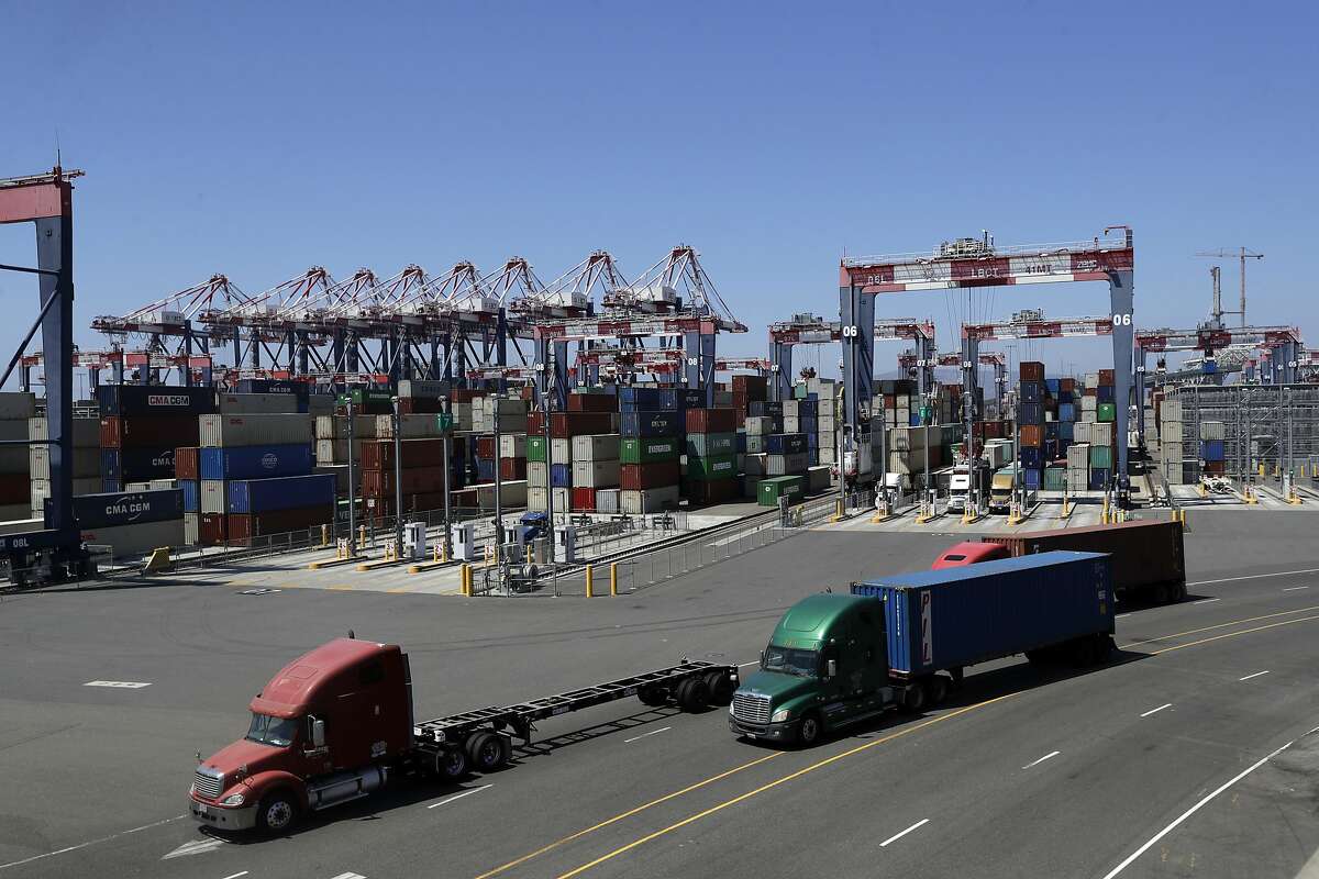 FILE - In this Aug. 22, 2018, file photo, trucks travel along a loading dock at the Port of Long Beach in Long Beach, Calif. The California Air Resources Board is scheduled to vote Thursday, June 25, 2020, on new first-in-the-nation rules to require a certain percentage of work truck sales each year must be electric vehicles. When the rule is fully implemented by 2035, the board estimates it will result in at least 20% of all delivery vans and work trucks on the road will be electric vehicles. (AP Photo/Marcio Jose Sanchez, File)