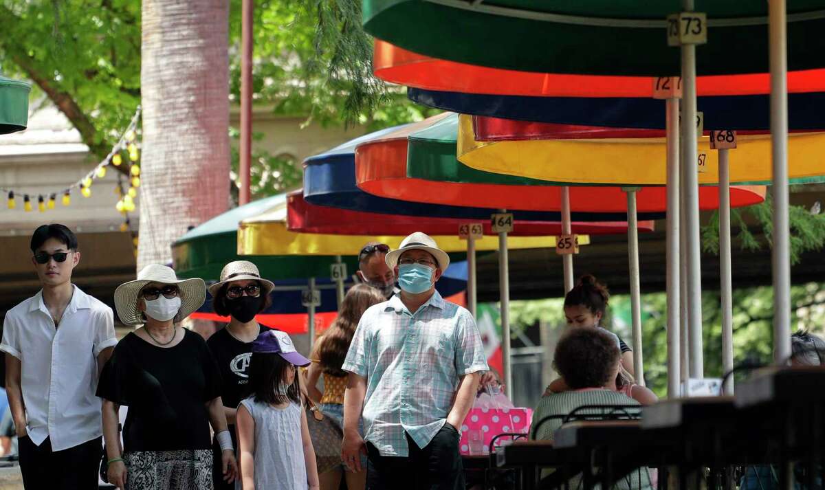 Visitors, some wearing masks to protect against the spread of COVID-19, walk along the River Walk in San Antonio, Wednesday, June 24, 2020, in San Antonio. Cases of COVID-19 have spiked in Texas and the governor of Texas is encouraging people to wear masks in public and stay home if possible. (AP Photo/Eric Gay)