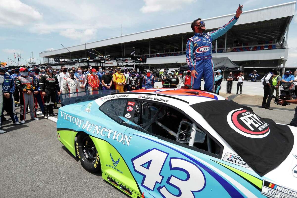 FILE - In this June 22, 2020, file photo, Bubba Wallace takes a selfie of himself and of other drivers who had pushed his car to the front in the pits at Talladega Superspeedway before the NASCAR Cup Series auto race in Talladega Ala., Monday June 22, 2020. The noose found hanging in Wallace's garage stall at Talladega had been there since at least last October, federal authorities said Tuesday, June 23, in announcing there will be no charges filed in an incident that rocked NASCAR and its only fulltime Black driver. (AP Photo/John Bazemore, File)